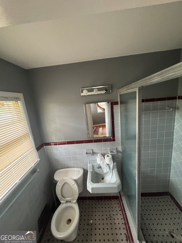 bathroom featuring walk in shower, tile walls, and toilet