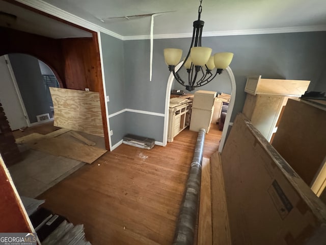 dining space with a notable chandelier, light hardwood / wood-style flooring, and ornamental molding