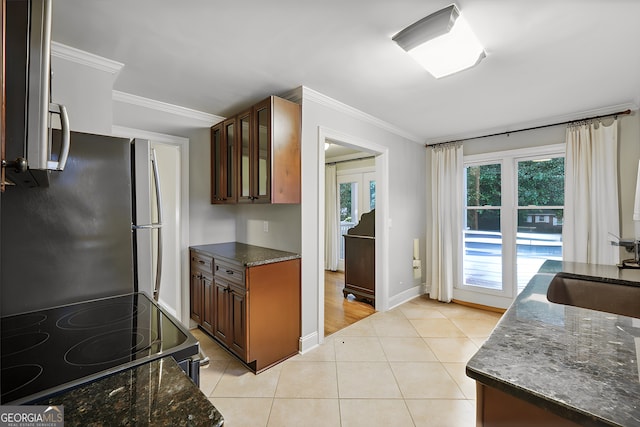 kitchen with light tile patterned flooring, crown molding, black range oven, and stainless steel refrigerator