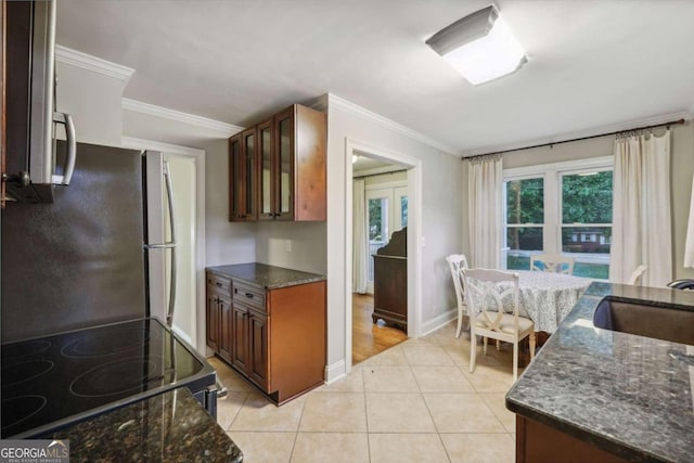 kitchen with light tile patterned floors, black range, stainless steel fridge, and ornamental molding