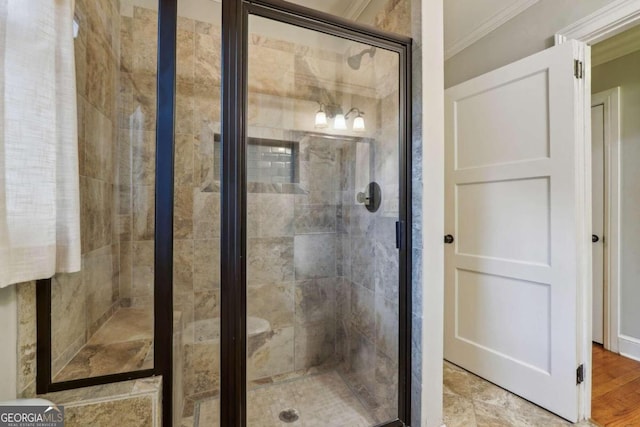 bathroom featuring ornamental molding, an enclosed shower, and wood-type flooring