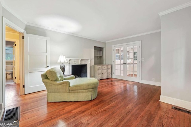 living room featuring french doors, crown molding, and hardwood / wood-style floors