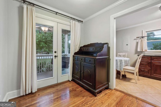 entryway with light wood-type flooring, crown molding, electric panel, and french doors