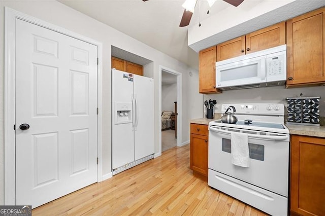 kitchen featuring ceiling fan, light wood-type flooring, and white appliances