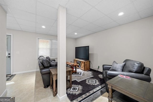 living room with a drop ceiling and tile patterned flooring