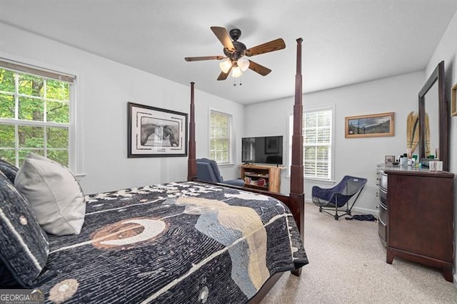 bedroom with multiple windows, light colored carpet, and ceiling fan