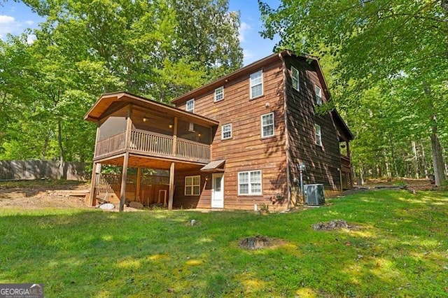 rear view of house with a yard, a balcony, and central air condition unit