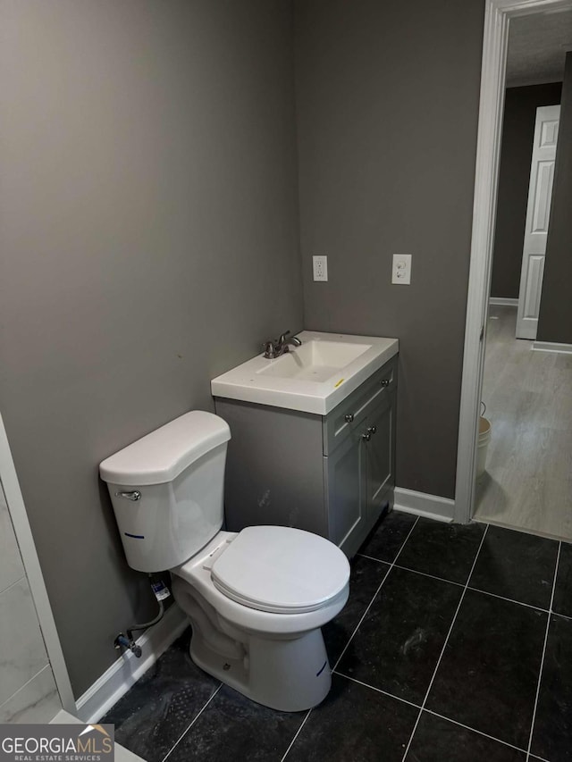 bathroom with tile patterned flooring, vanity, and toilet