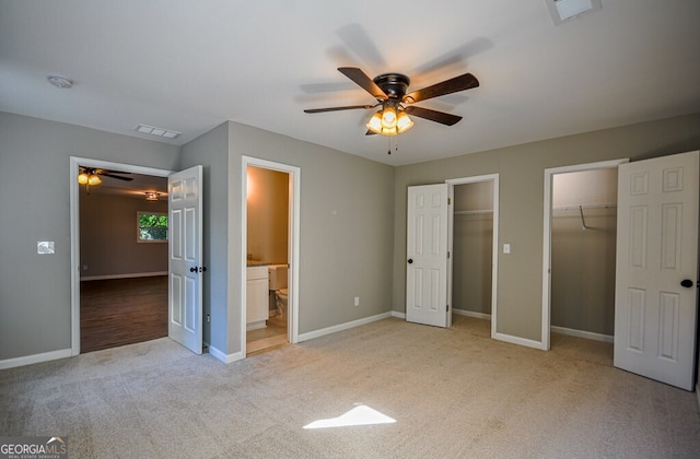 unfurnished bedroom with ceiling fan, connected bathroom, and light carpet