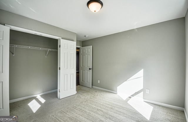 unfurnished bedroom featuring light colored carpet and a closet