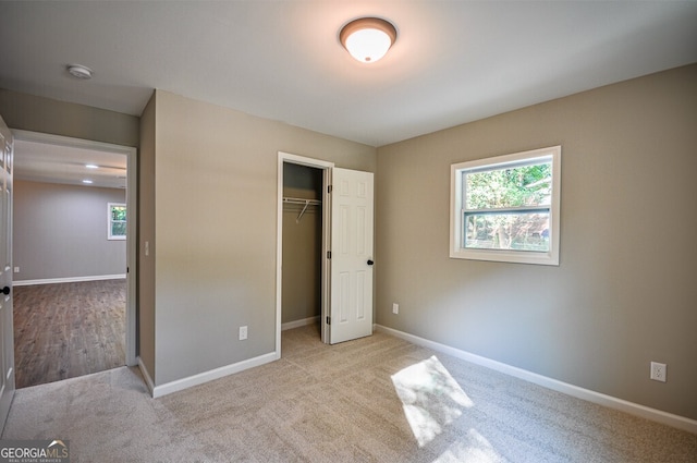 unfurnished bedroom featuring a closet and light colored carpet