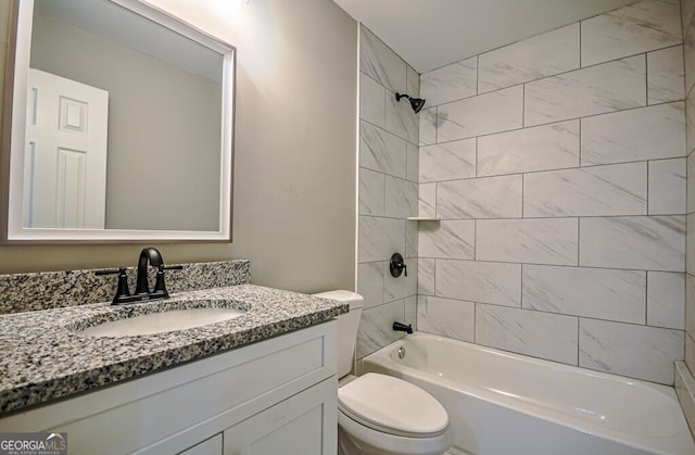 full bathroom with vanity, tiled shower / bath combo, and toilet