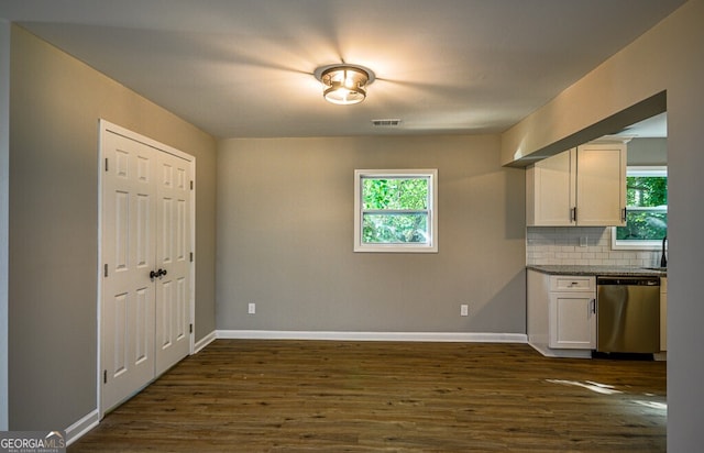 kitchen featuring dark hardwood / wood-style flooring, white cabinetry, plenty of natural light, and stainless steel dishwasher