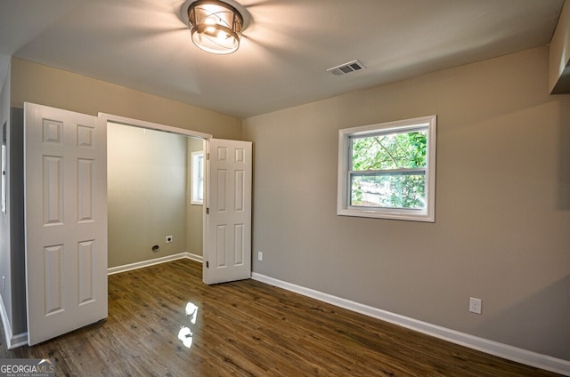 unfurnished bedroom featuring a closet and dark hardwood / wood-style floors