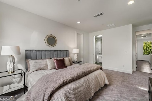 bedroom featuring ensuite bathroom and carpet floors