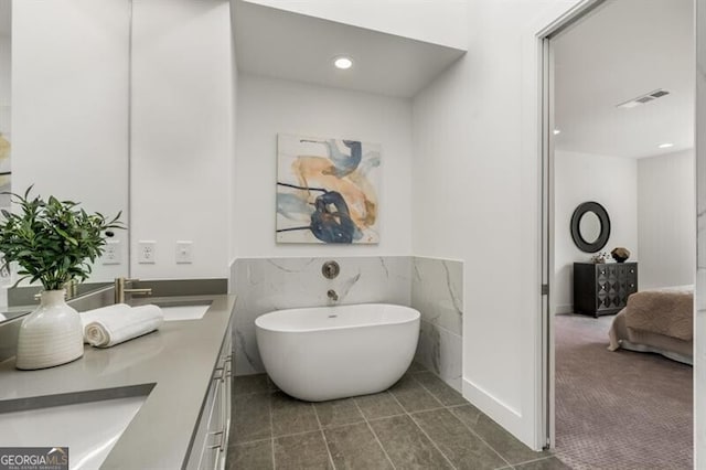 bathroom featuring tile patterned floors, vanity, and a tub