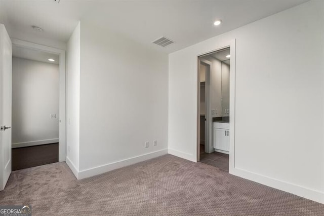 unfurnished bedroom featuring ensuite bathroom and carpet floors