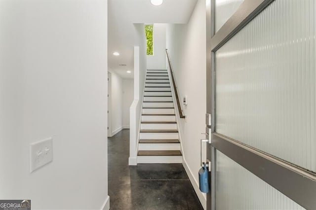 stairway with concrete flooring