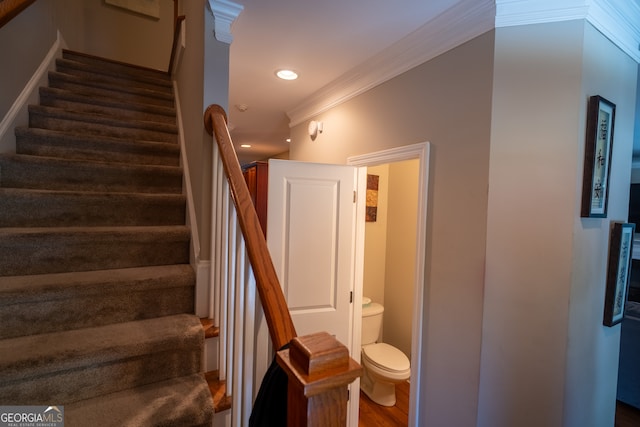 stairway featuring wood-type flooring and crown molding