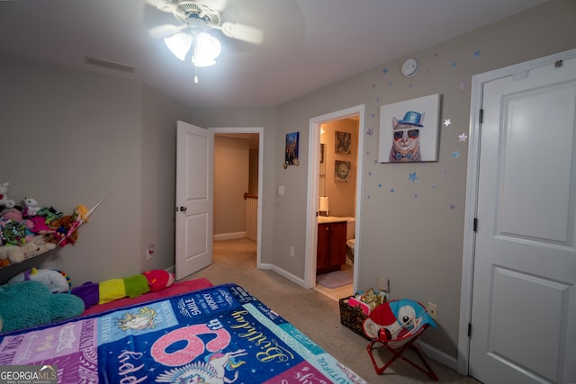 bedroom with ceiling fan, light carpet, and ensuite bath