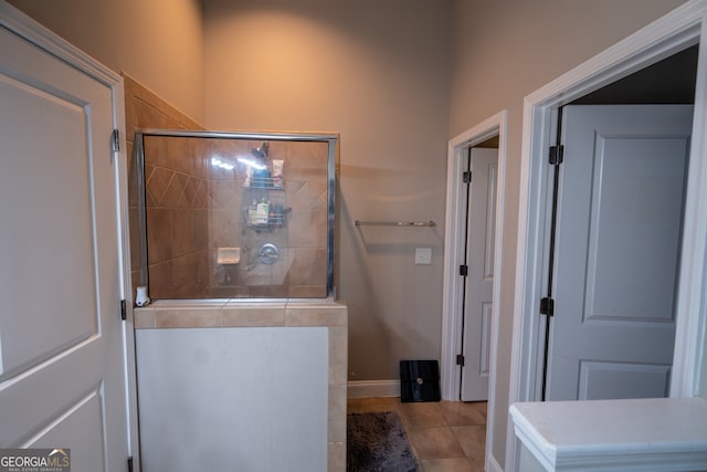 bathroom with tile patterned floors and tiled shower