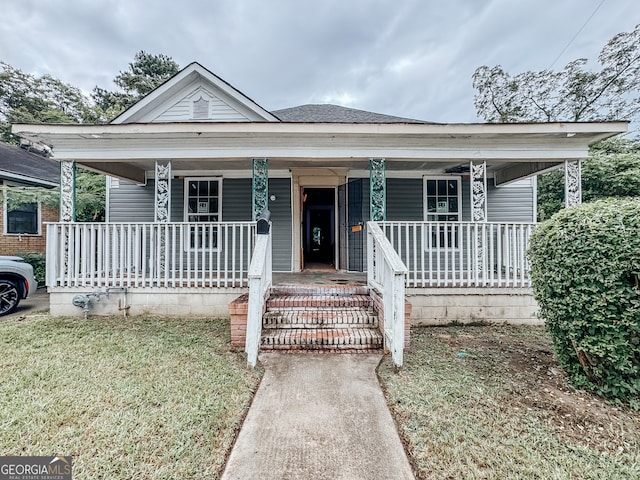 bungalow-style house featuring covered porch and a front yard