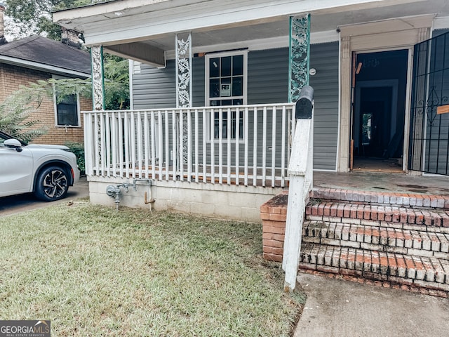 exterior space with covered porch and a yard