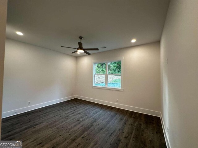 spare room with dark hardwood / wood-style floors and ceiling fan