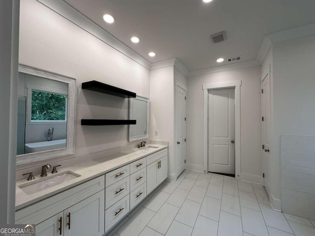 bathroom with tile patterned floors, a tub to relax in, vanity, and crown molding