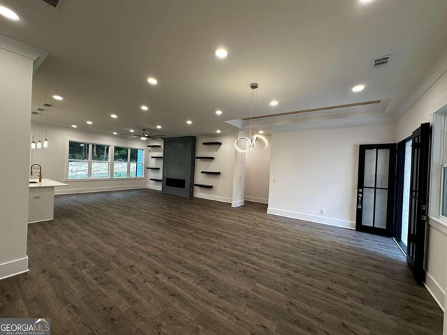 unfurnished living room with sink and dark hardwood / wood-style flooring