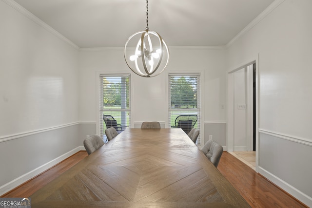 dining area with light wood-type flooring, crown molding, and an inviting chandelier