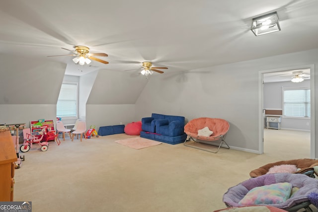 recreation room with lofted ceiling, ceiling fan, and light colored carpet