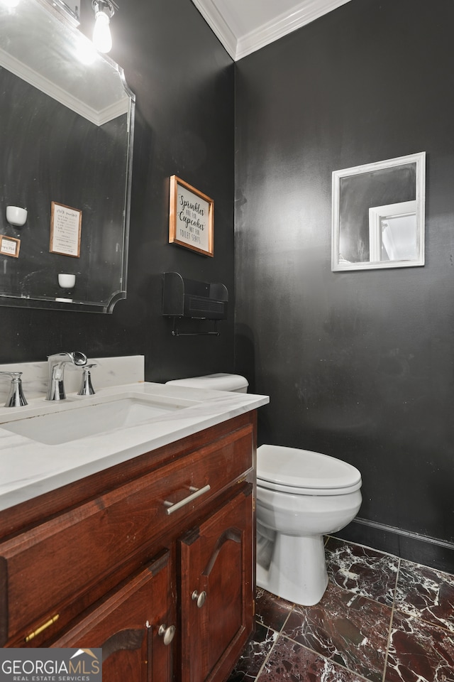 bathroom with ornamental molding, vanity, and toilet