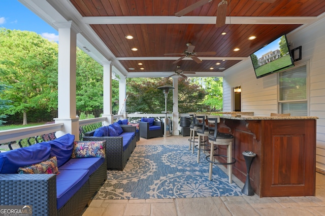 view of patio featuring an outdoor living space, ceiling fan, and a bar