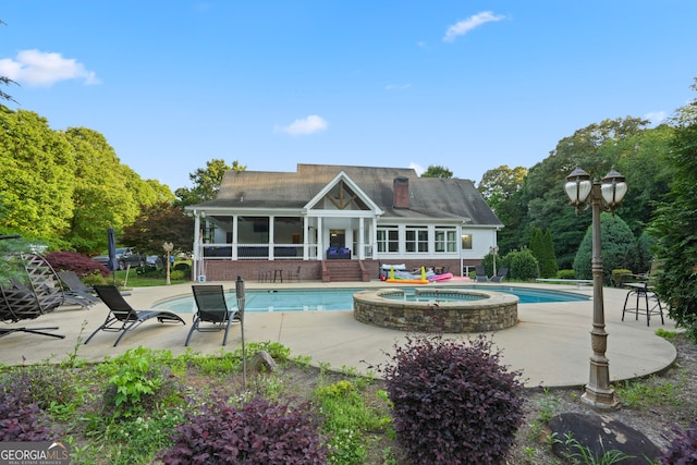 view of pool featuring a patio and an in ground hot tub