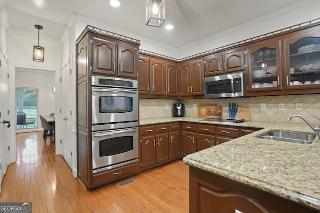 kitchen featuring appliances with stainless steel finishes, crown molding, light hardwood / wood-style floors, and sink