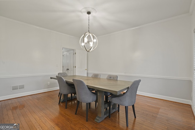 dining area featuring hardwood / wood-style flooring and crown molding