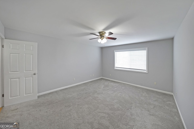 carpeted spare room with ceiling fan