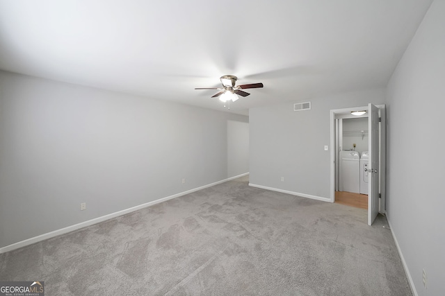 unfurnished bedroom featuring washer and dryer, light carpet, and ceiling fan