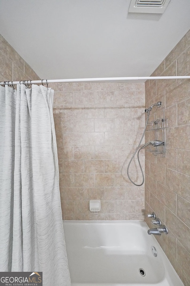 bathroom with shower / bath combo with shower curtain