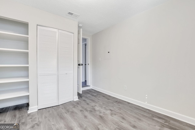 unfurnished bedroom featuring light hardwood / wood-style floors and a textured ceiling