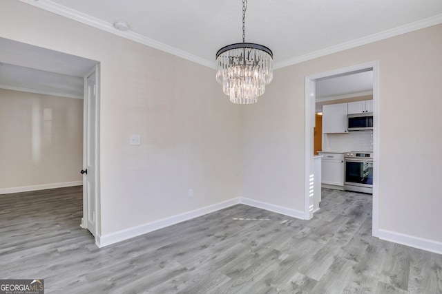 unfurnished dining area featuring crown molding, light hardwood / wood-style flooring, and an inviting chandelier