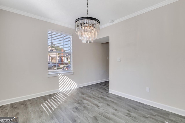 unfurnished dining area featuring ornamental molding, a chandelier, and wood-type flooring