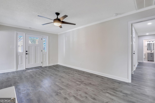 unfurnished room with ceiling fan, crown molding, dark wood-type flooring, and a textured ceiling