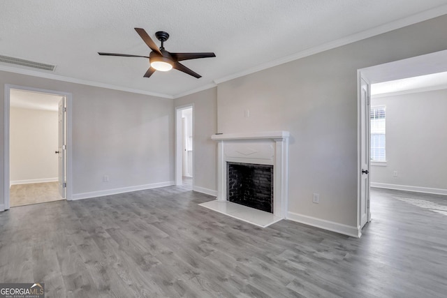 unfurnished living room with a textured ceiling, light hardwood / wood-style floors, ceiling fan, and crown molding