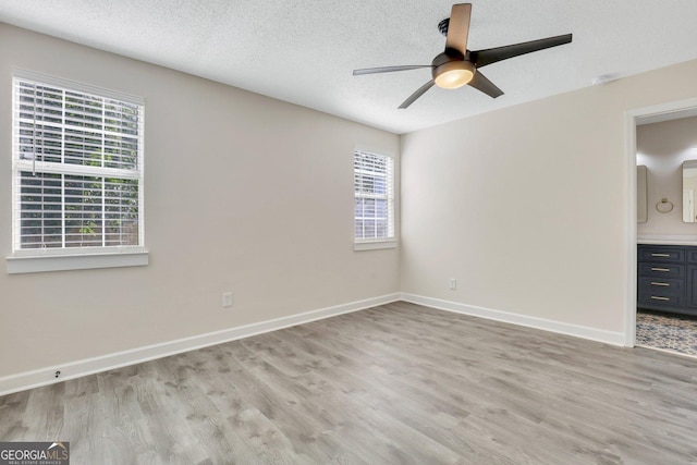 unfurnished room featuring a textured ceiling, light hardwood / wood-style flooring, and ceiling fan