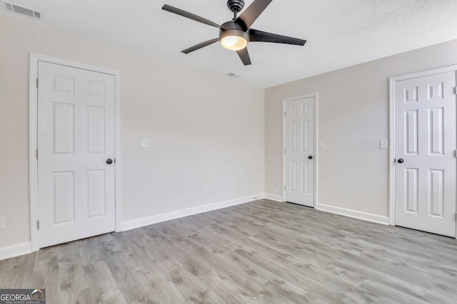 unfurnished bedroom with ceiling fan, light hardwood / wood-style flooring, and a textured ceiling