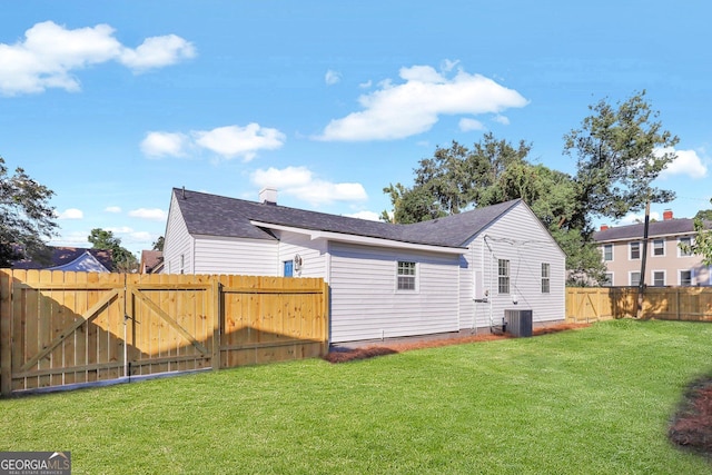 back of property with a yard and central AC unit