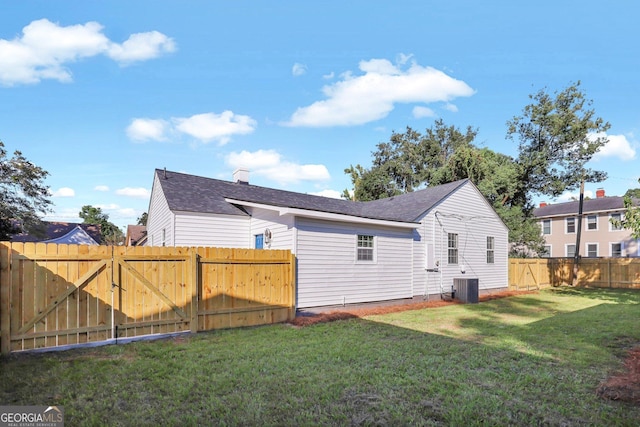 back of house featuring cooling unit and a lawn