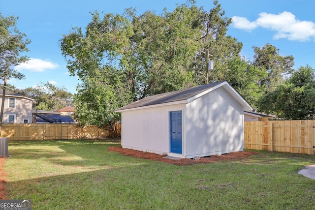 view of outdoor structure featuring a yard and cooling unit